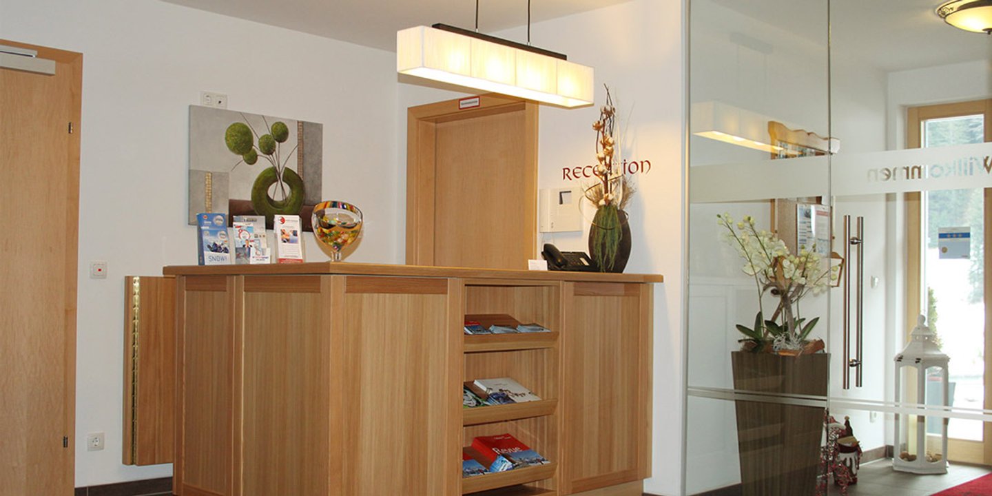 Rezeption des Hotel Garni Dorfblick in hellem Holz