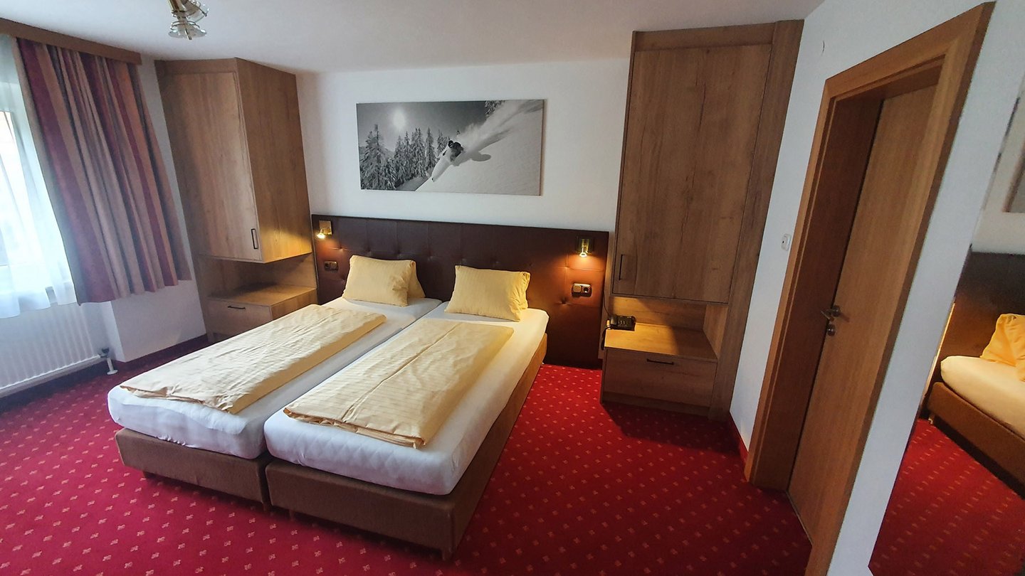 Doppelzimmer mit getrennten Betten und Sitzecke im Hotel Dorfblick