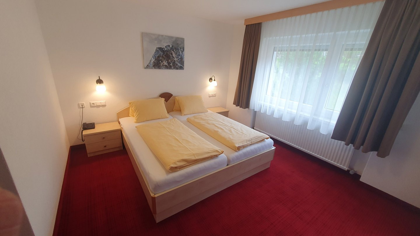 Doppelzimmer mit Doppelbett und großer Fensterfront