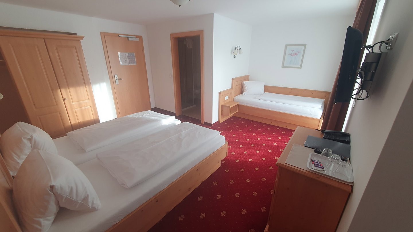 Dreibettzimmer im Hotel Dorfblick mit Holzmöbeln