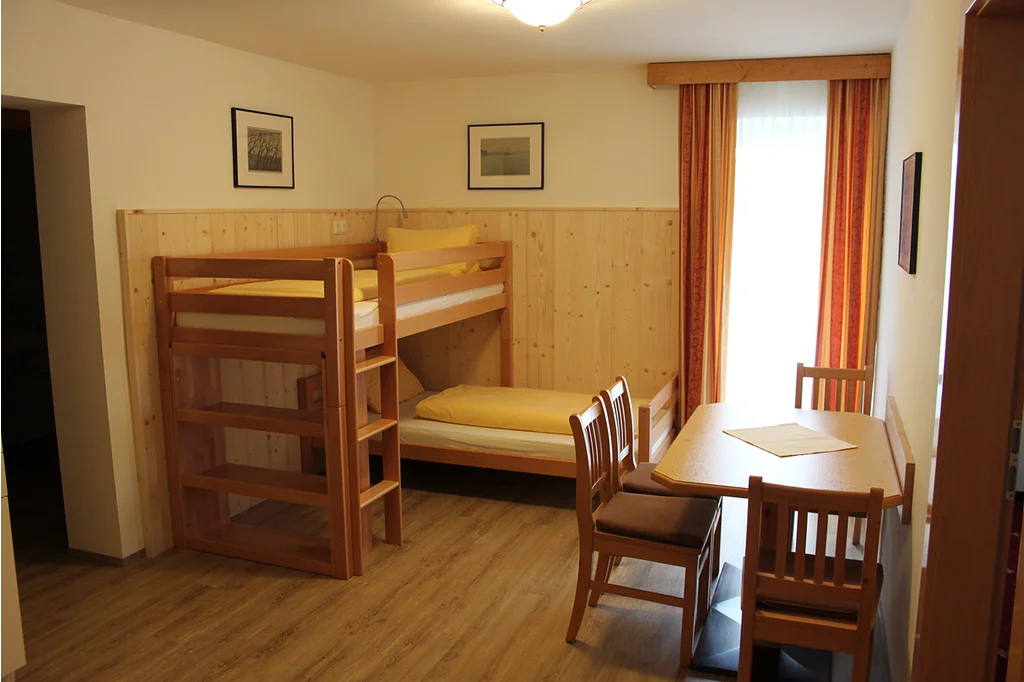 Appartement 01: Wohnraum mit Stockbett und Essplatz