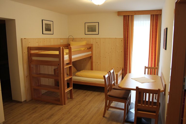 Appartement 01: Wohnraum mit Stockbett und Essplatz