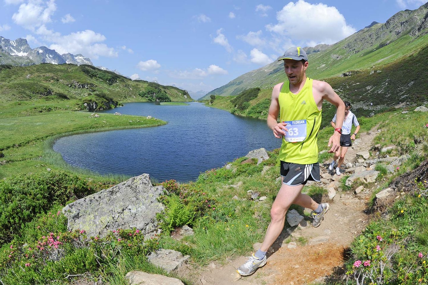 Trailrunner auf einem Steig oberhalb eines Bergsees