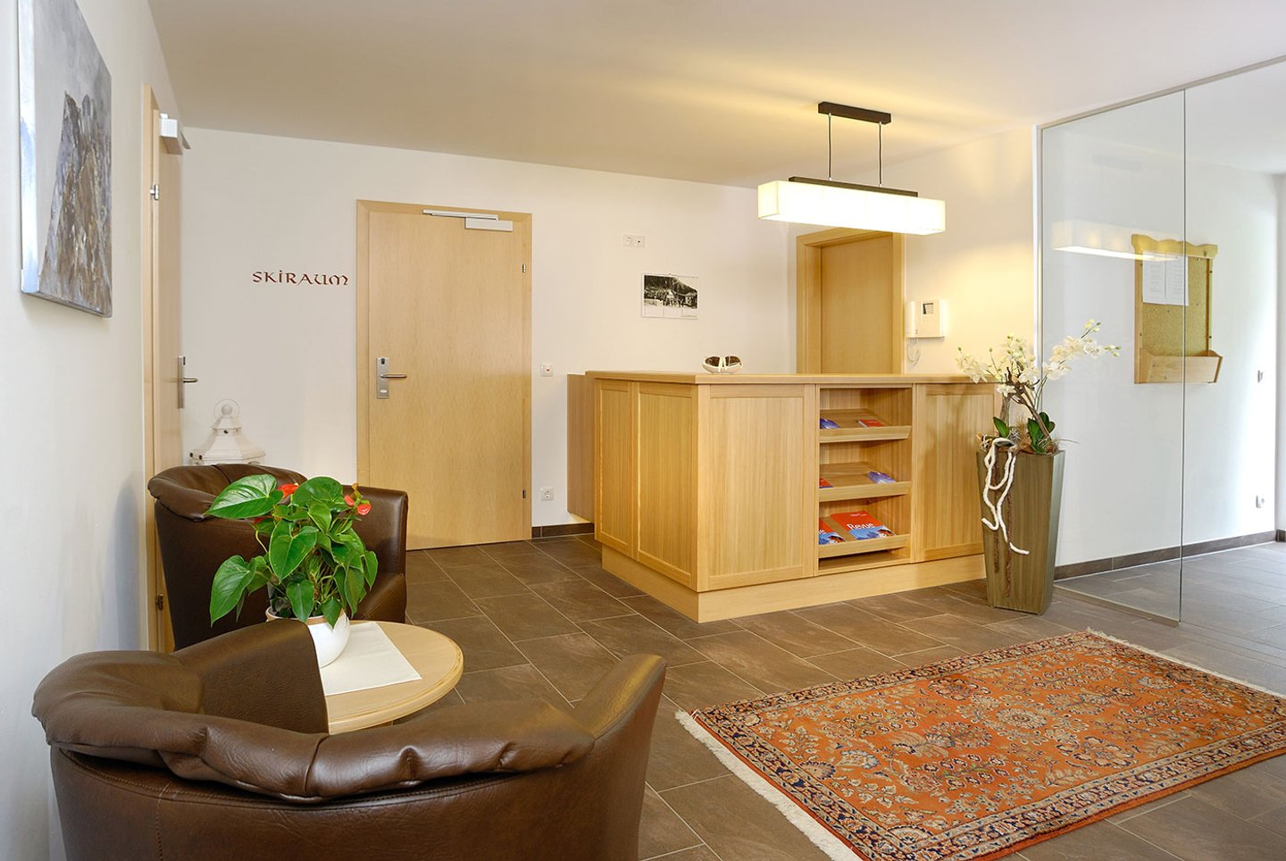 Eingangsbereich mit Rezeption und Sitzgelegenheit im Hotel Dorfblick